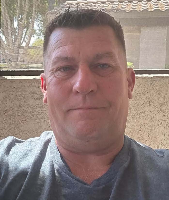 A man sitting in front of a window.